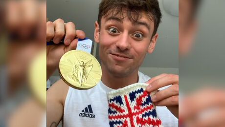 Tom Daley breit een houder om zijn gouden medaille